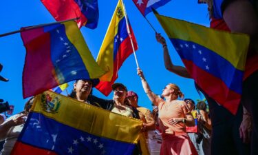 A woman holds a banner depicting Venezuelan opposition leader Maria Corina Machado as people react to the news in Doral