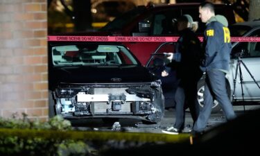 Police officers in riot gear stand guard as demonstrators gather outside the Portland ICE facility to protest after federal agents shot two people in Portland