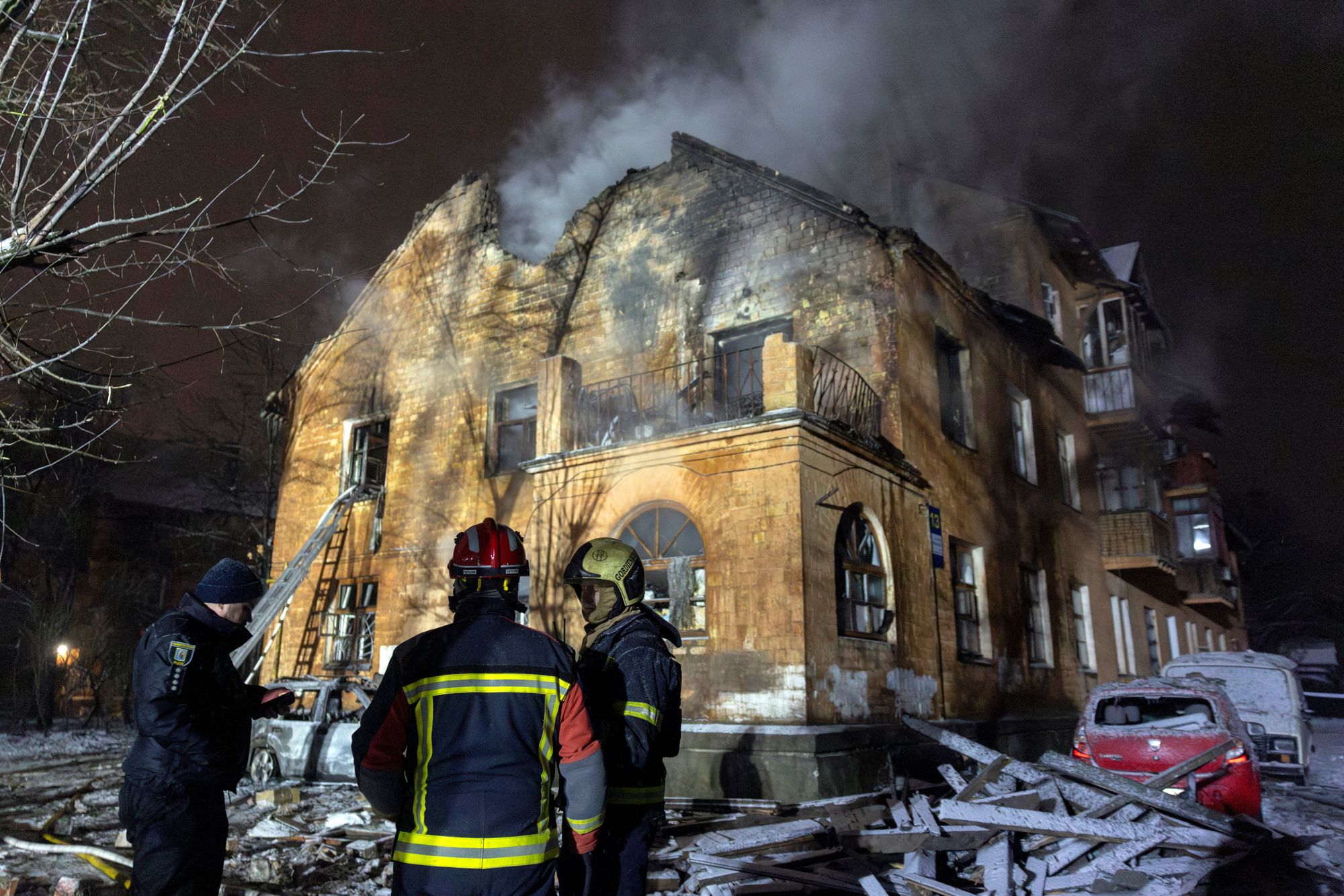 <i>Thomas Peter/Reuters via CNN Newsource</i><br/>Firefighters stand in front of a residential building that was hit during a night of Russian drone and missile attacks in the Ukrainian capital.