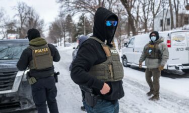 Federal agents detain a person in Minneapolis on Thursday.