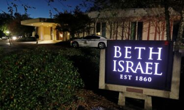 An armed Hinds County Sheriff's deputy is seen outside Beth Israel Congregation synagogue in Jackson