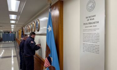FILE - Workers remove sign lettering at the Pentagon after President Donald Trump signed an executive order aiming to rename the Department of Defense the Department of War in Washington