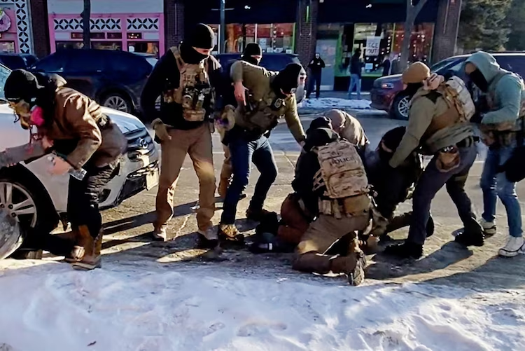 The moment that the firearm of a man identified as Alex Pretti is retrieved from a waistband holster by a federal officer (in light grey jacket, crouched) as another officer (in green) draws his weapon, before Pretti was fatally shot in Minneapolis, Minnesota, January 24, 2026.
