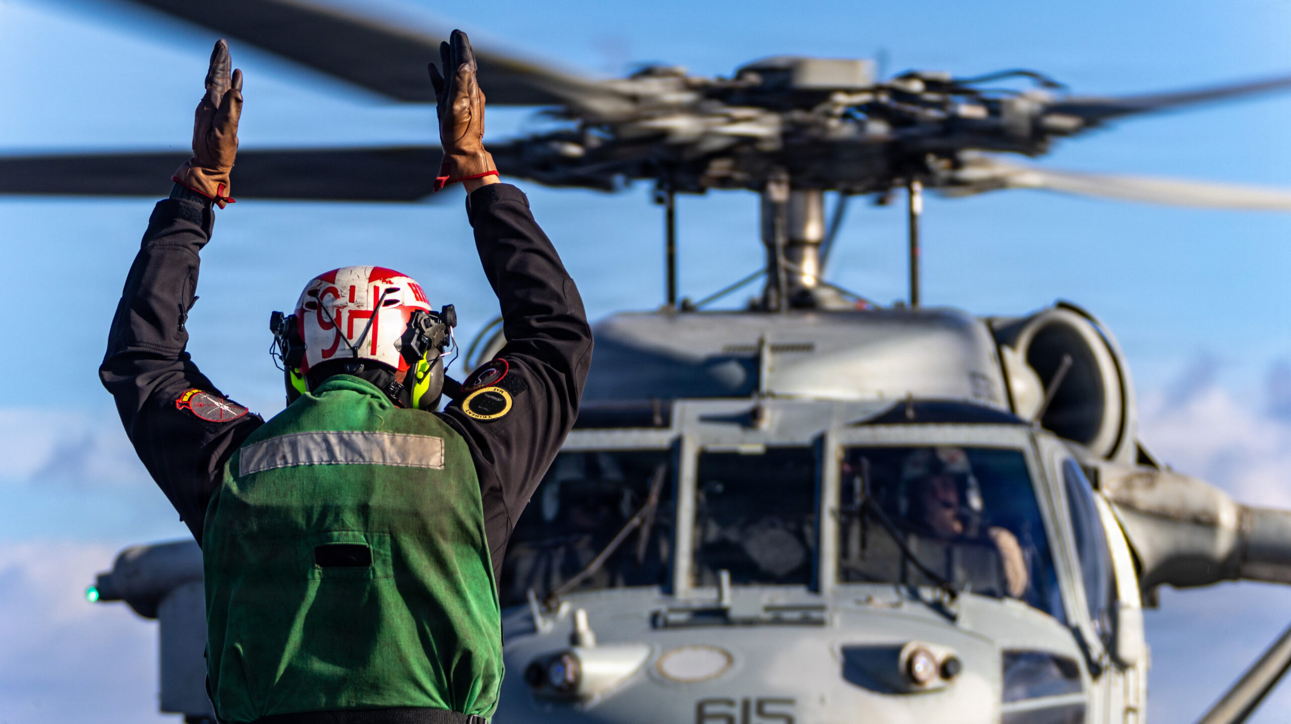 A U.S. Navy Sailor signals an MH-60S Sea Hawk helicopter, attached to Helicopter Sea Combat Squadron 9, from the flight deck of the world's largest aircraft carrier, USS Gerald R. Ford (CVN 78), while operating in support of Operation Epic Fury, Feb. 28, 2026. (U.S. Navy photo)