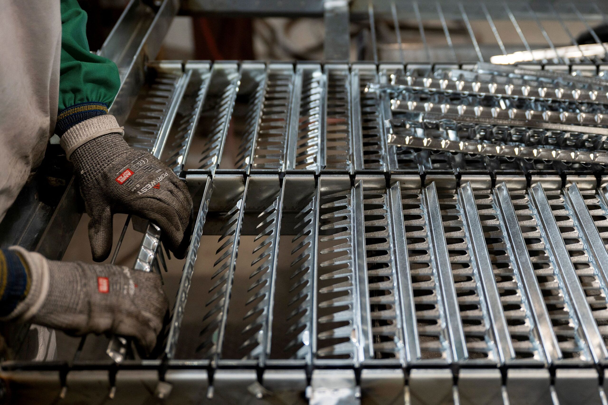 <i>Vincent Alban/Reuters via CNN Newsource</i><br/>A worker handles components for a steel sieve at HCC