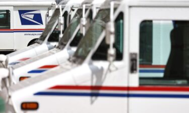 U.S. Postal Service (USPS) trucks are parked at a post office on August 23