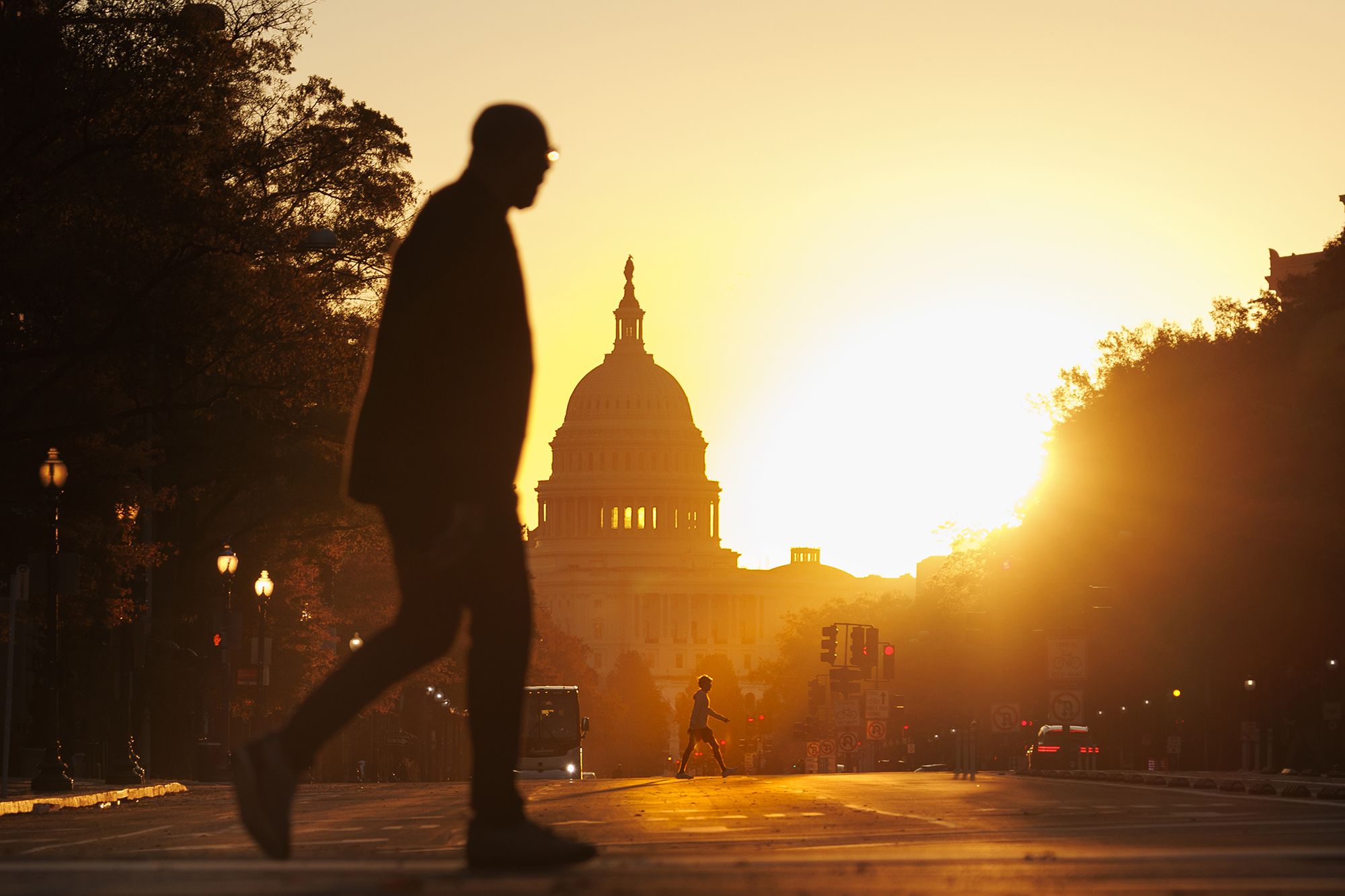 <i>Tom Brenner/Getty Images via CNN Newsource</i><br/>Pedestrians walks along Pennsylvania Avenue near the U.S. Capitol during sunrise on November 5