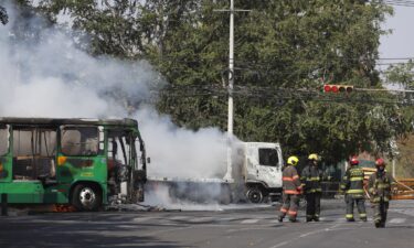 Police officers secure an area where vehicles were set on fire following the operation against Mexican drug lord Nemesio Oseguera