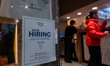 A restaurant displays a 'hiring' sign in its window in Manhattan on December 16