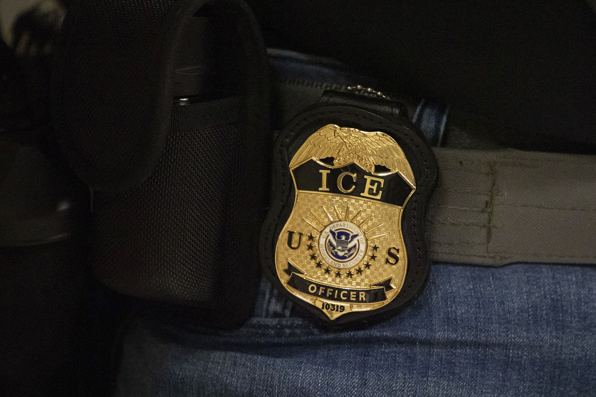 <i>Yuki Iwamura/AP via CNN Newsource</i><br/>A federal agent wears a badge of Immigration and Customs Enforcement while standing outside an immigration courtroom at the Jacob K. Javits Federal Building in New York