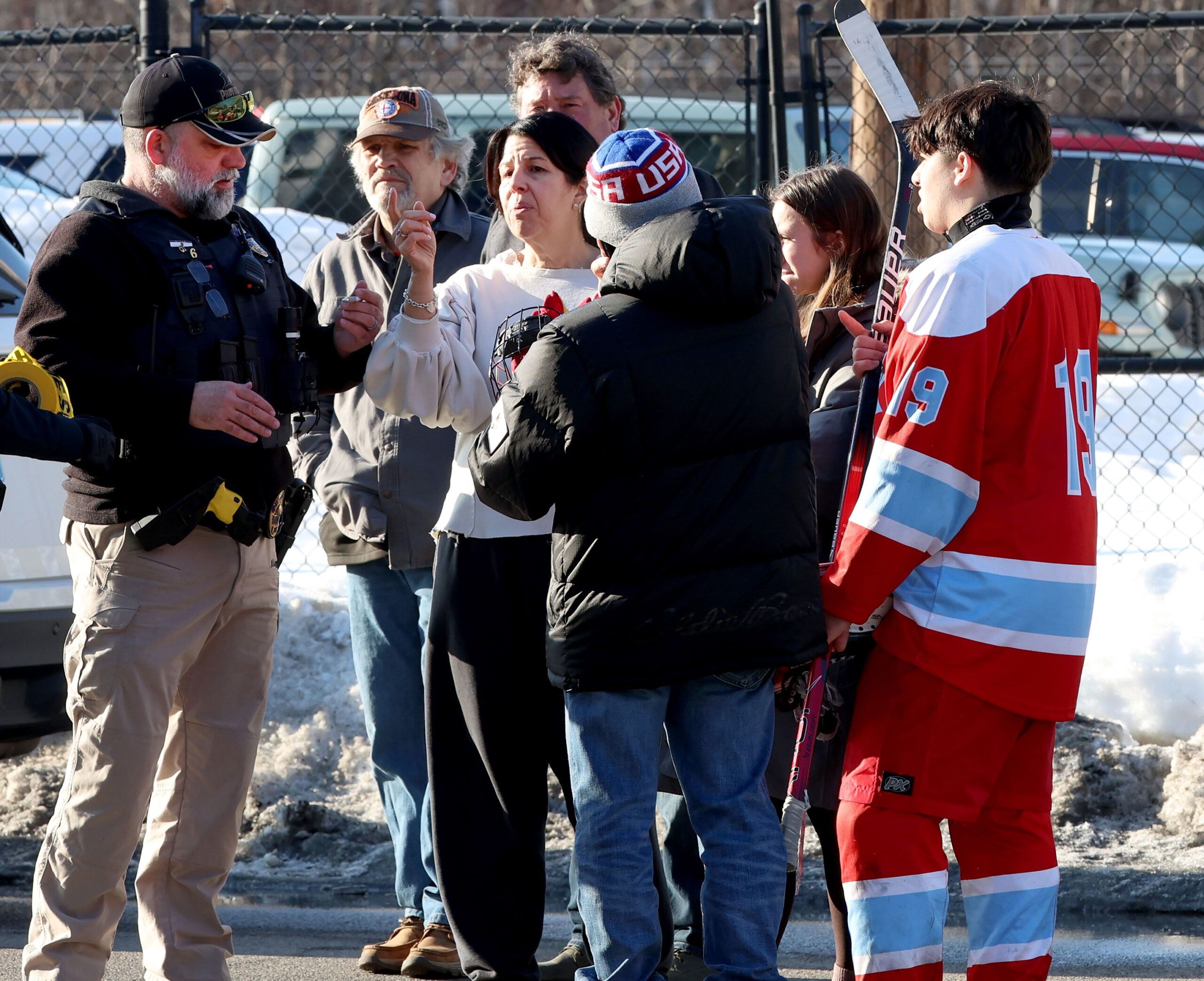 Hockey parents and a player speak to a police officer outside of the Lynch Arena in Pawtucket, Rhode Island, after a shooting at the ice rink, Monday, February. 16, 2026.