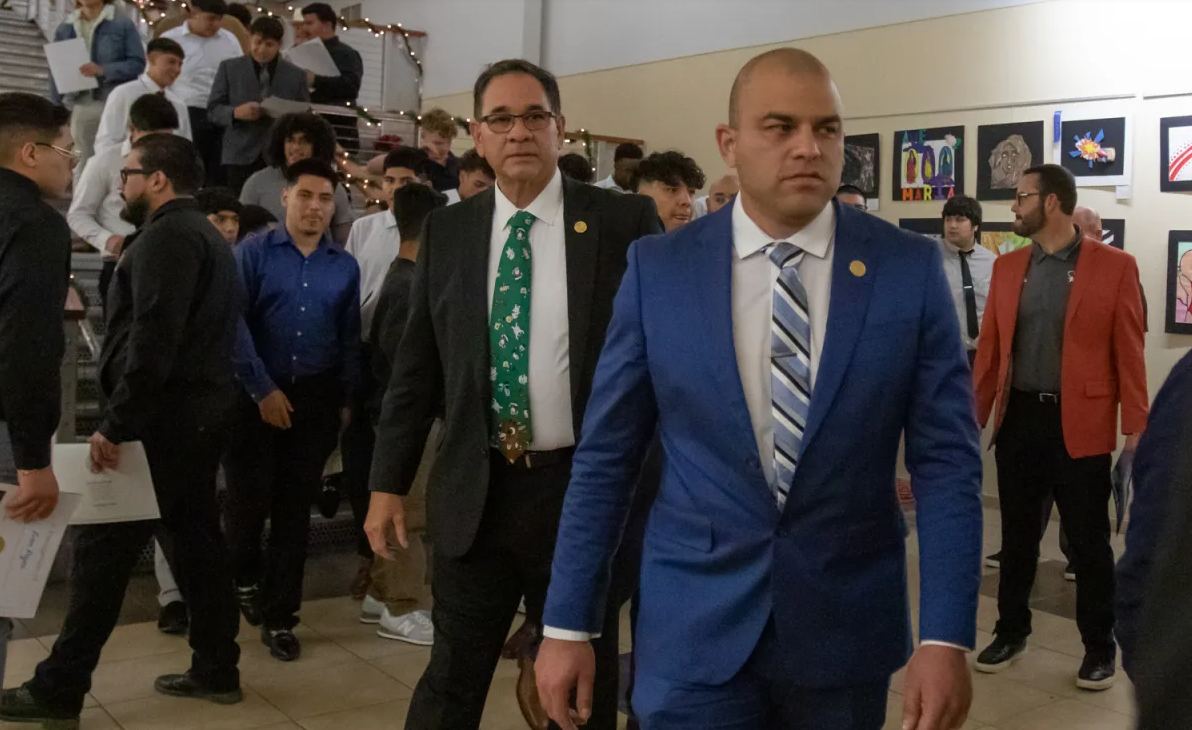 Trustees Ricardo Castellano, left, and Pablo Barrera return to the board room after taking a photo with Socorro Independent School District students during a board meeting in 2022. (Corrie Boudreaux/El Paso Matters)