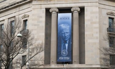 A banner of President Trump hangs from the Department of Justice building in Washington