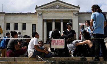 A man rides a tricycle with his leashed dog running alongside him during a blackout in Havana