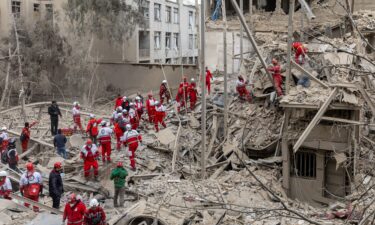 Emergency crews search for people trapped in rubble following a strike on a residential building in Tehran