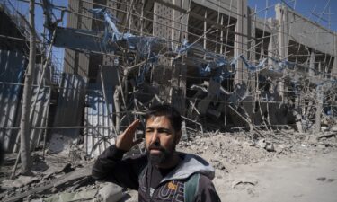 Firefighters inspect destruction at the site of an Israeli airstrike in the southern suburbs of Beirut