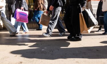 People walk along Broadway with shopping bags on February 27