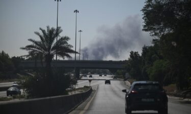 Motorists drive along a street as smoke rises from a reported Iranian strike in the area where the US Embassy is located in Kuwait City on March 2.