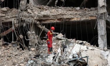 An Iranian firefighter walks on the rubble of a destroyed residential building in Tehran