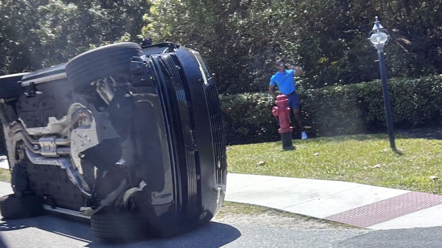 Golfer Tiger Woods stands by his overturned vehicle in Jupiter Island, Fla., on Friday, March 27.