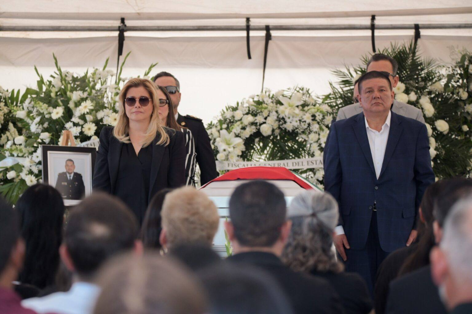 Chihuahua Gov. Maria Eugenia "Maru" Campos Galván and State Attorney General César César Jáuregui Moreno stand next to a casket at a memorial April 20, 2026 for two investigators with the state police. Director of the Chihuahua State Investigation agency Pedro Román Oseguera and agent Manuel Genaro Montes and two CIA agents died when the vehicle they were in crashed April 19, 2021.