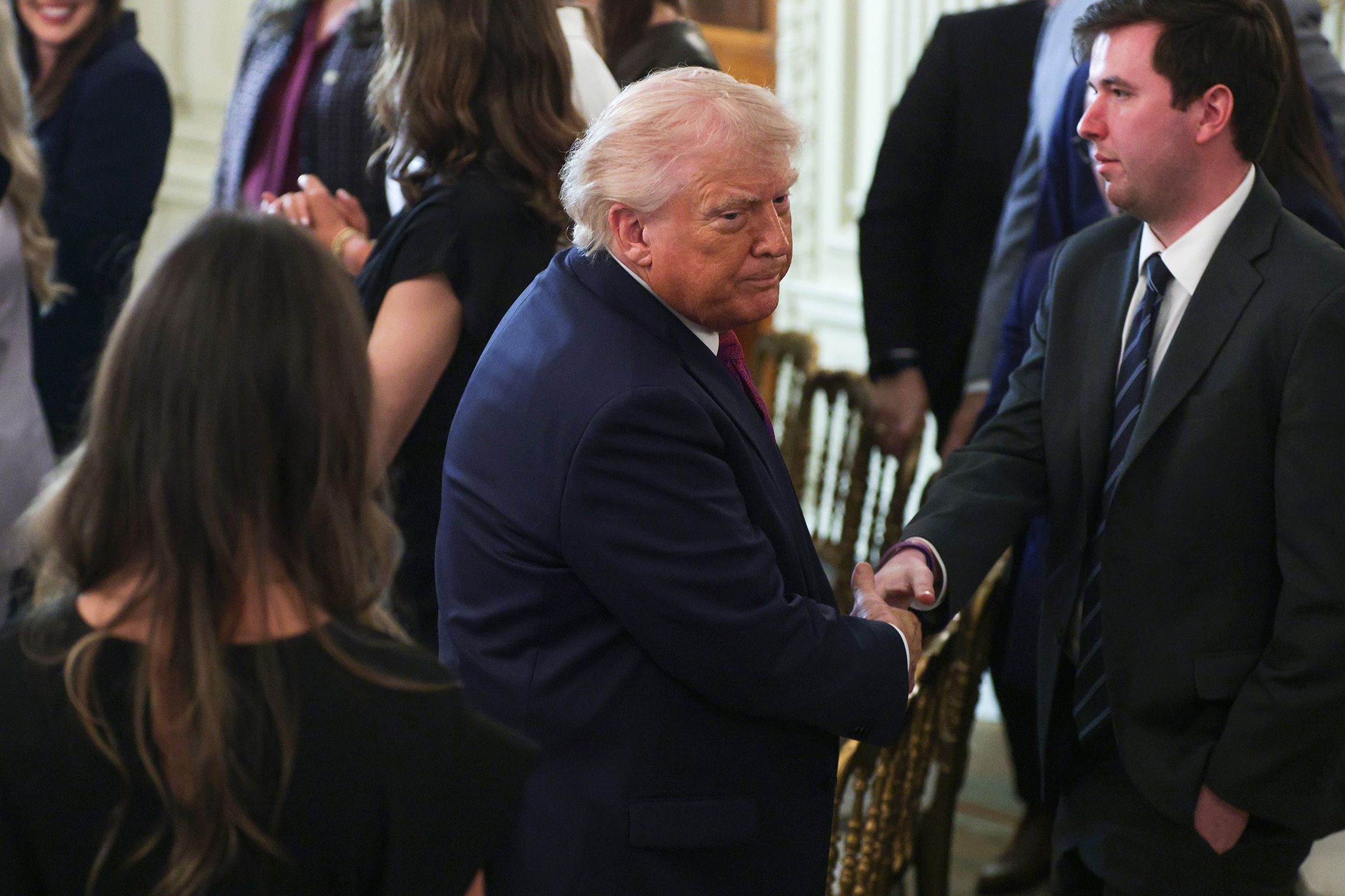 <i>Alex Wong/Getty Images via CNN Newsource</i><br/>President Donald Trump shakes hands as he departs after making remarks during a NCAA Collegiate National Champions Day event