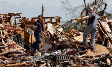 Men look through damage following a tornado in Enid