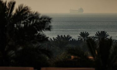 A photograph taken from the town of Al Jeer in the northern emirate of Ras Al Khaimah shows a tanker passing through the waters of the Strait of Hormuz on February 25.