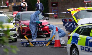 A forensic police officers photograph the scene where two people were stabbed on Wednesday