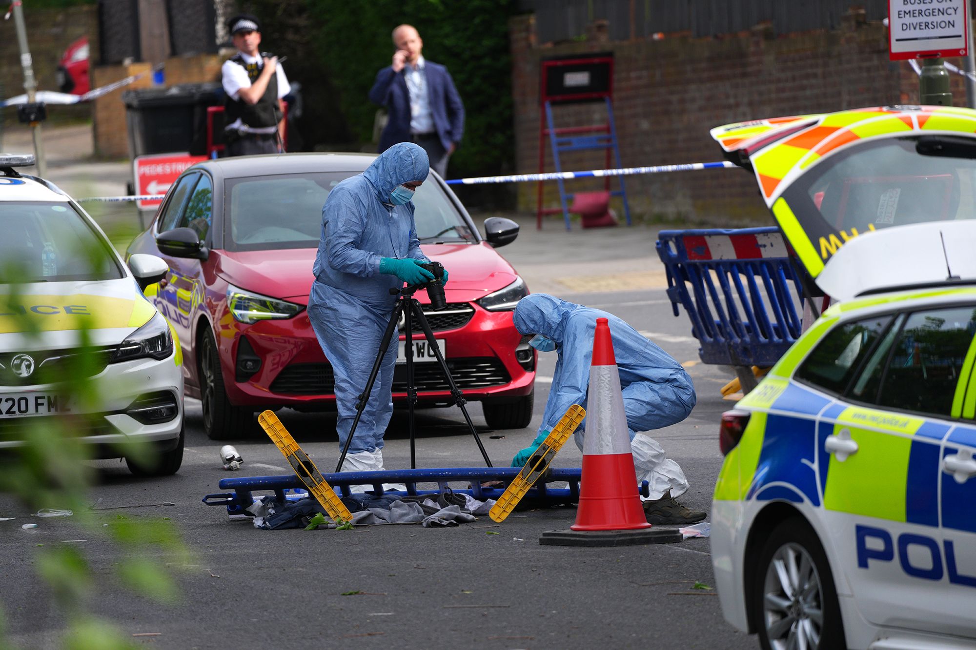 <i>Carl Court/Getty Images via CNN Newsource</i><br/>A forensic police officers photograph the scene where two people were stabbed on Wednesday