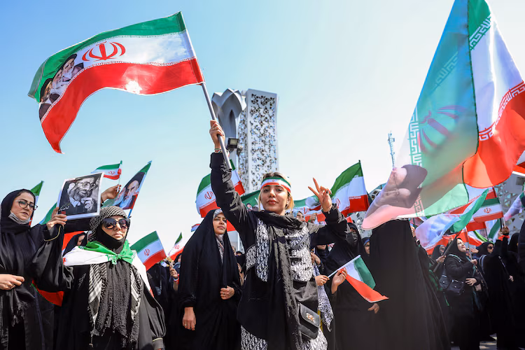 An Iranian woman flashes the V-sign as she takes part in a rally dubbed "Sacrificed Girls" to pay tribute to women killed during Middle East war, in Tehran on April 17, 2026.