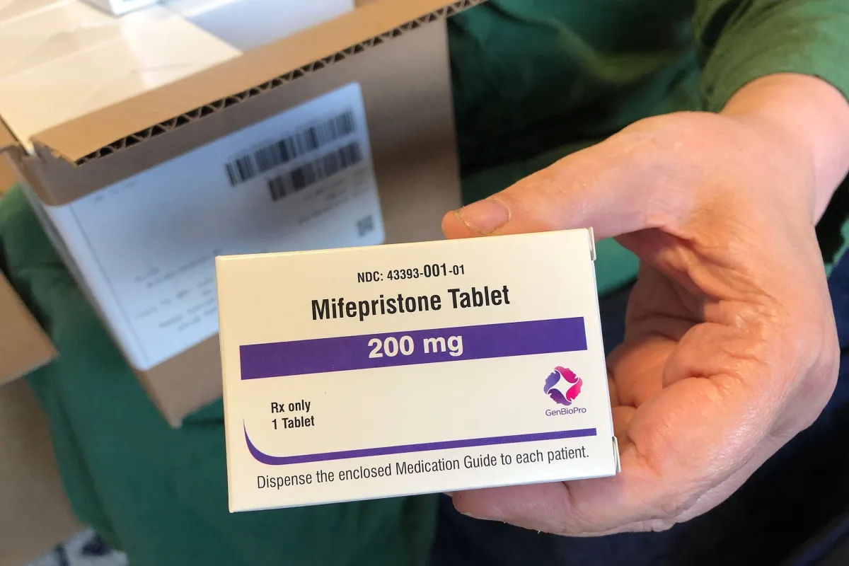 Nurse practitioner Debra Lynch holds a box of mifepristone, the first drug used in a medication abortion regimen. Practicing under Delaware's shield law, Lynch prescribes the pills via telehealth, largely to patients in abortion-restricted states like Texas.