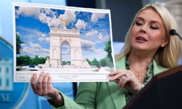 White House Press Secretary Karoline Leavitt holds up a rendering of President Donald Trump's proposed arch during a press briefing in April.