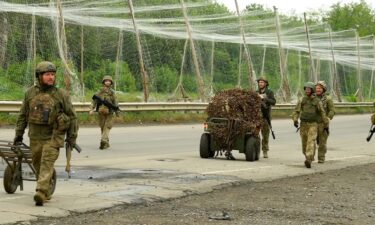 Ukrainian soldiers walk along the so-called "Road of Life" in eastern Ukraine
