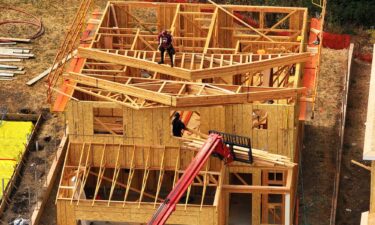 Construction workers build a home at a new housing development on July 1
