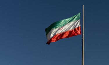 The Iranian national flag flies atop a pole at Bam-e Tehran in Tehran