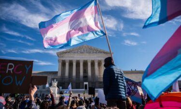 Protesters wave transgender pride flags outside the Supreme Court as it hears arguments over state laws barring transgender girls and women from playing on school athletic teams in January in Washington