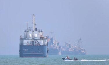 A small motorboat passes anchored vessels in the Strait of Hormuz off Bandar Abbas