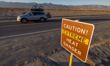 A car passes a sign warning of extreme heat danger on the eve of a day that could set a new world heat record in Death Valley National Park on July 15