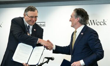 TotalEnergies CEO Patrick Pouyanne (left) shakes hands with US Interior Sec. Doug Burgum after signing a nearly $1 billion taxpayer-funded agreement to end the French company's offshore US wind farm projects and redirect those funds towards fossil fuel production.