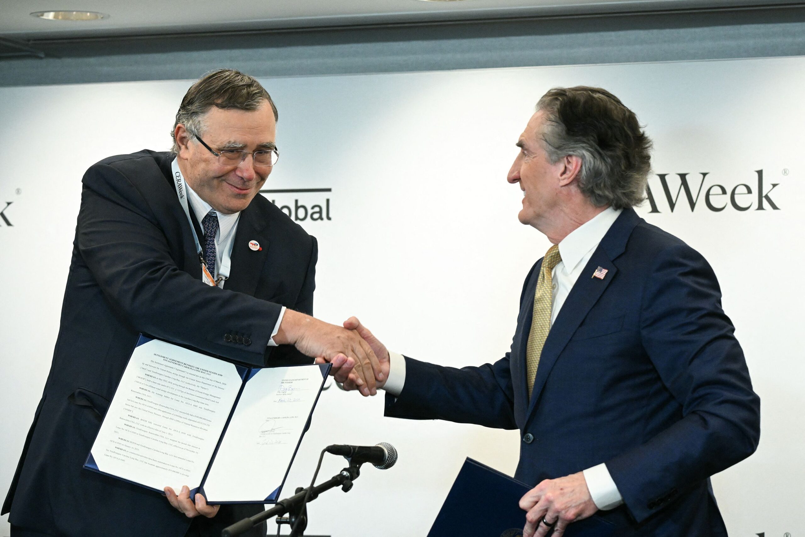 <i>Ronaldo Schemidt/AFP/Getty Images via CNN Newsource</i><br/>TotalEnergies CEO Patrick Pouyanne (left) shakes hands with US Interior Sec. Doug Burgum after signing a nearly $1 billion taxpayer-funded agreement to end the French company's offshore US wind farm projects and redirect those funds towards fossil fuel production.