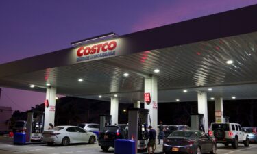 Customers pump gasoline at a Costco Wholesale gas station on March 18
