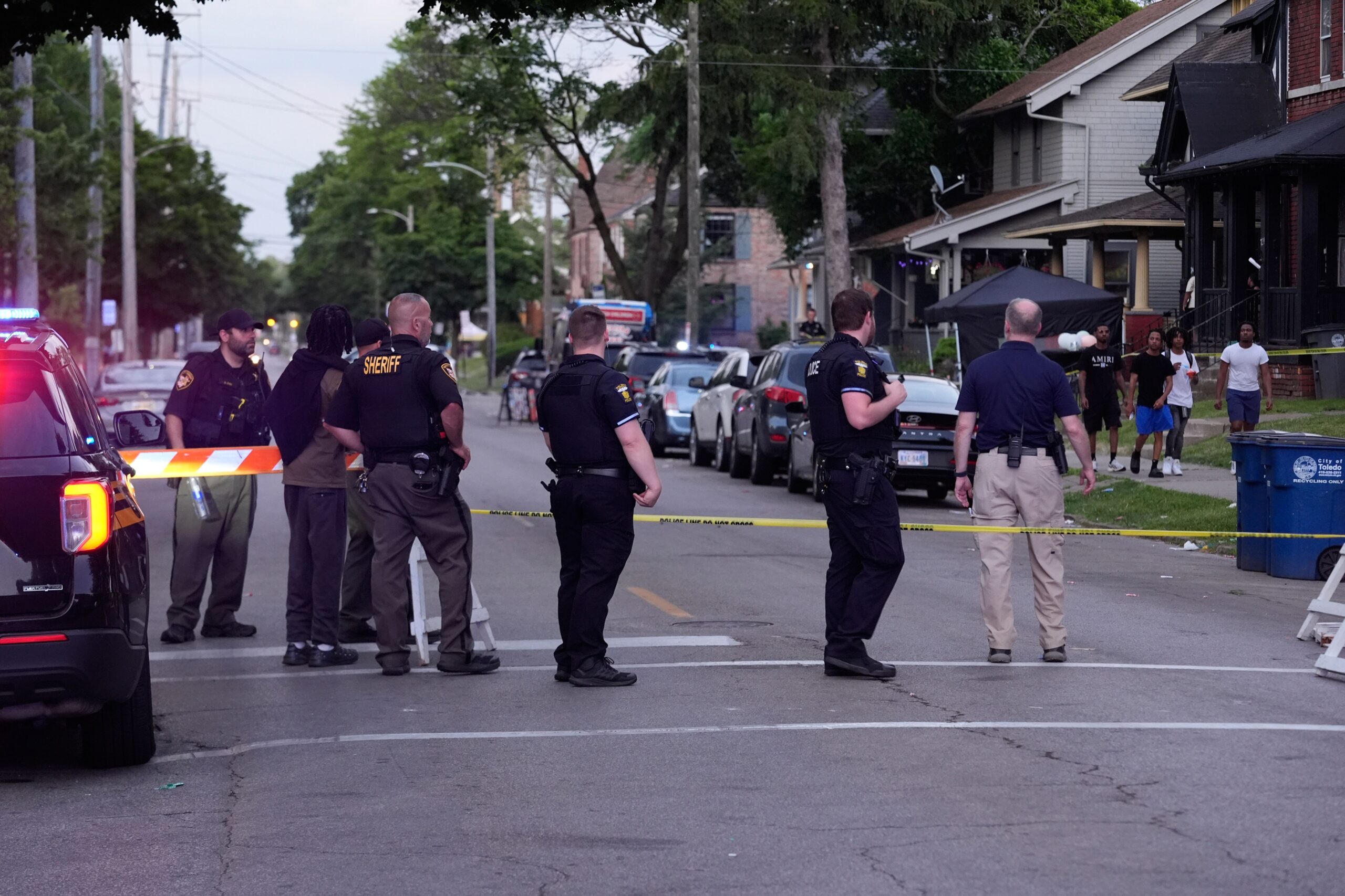 <i>Paul Sancya/AP via CNN Newsource</i><br/>Police stand near where multiple people were shot at a community festival