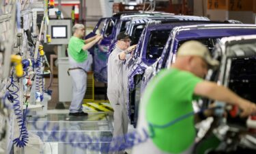 Volkswagen workers check electric cars at one of the company's factories