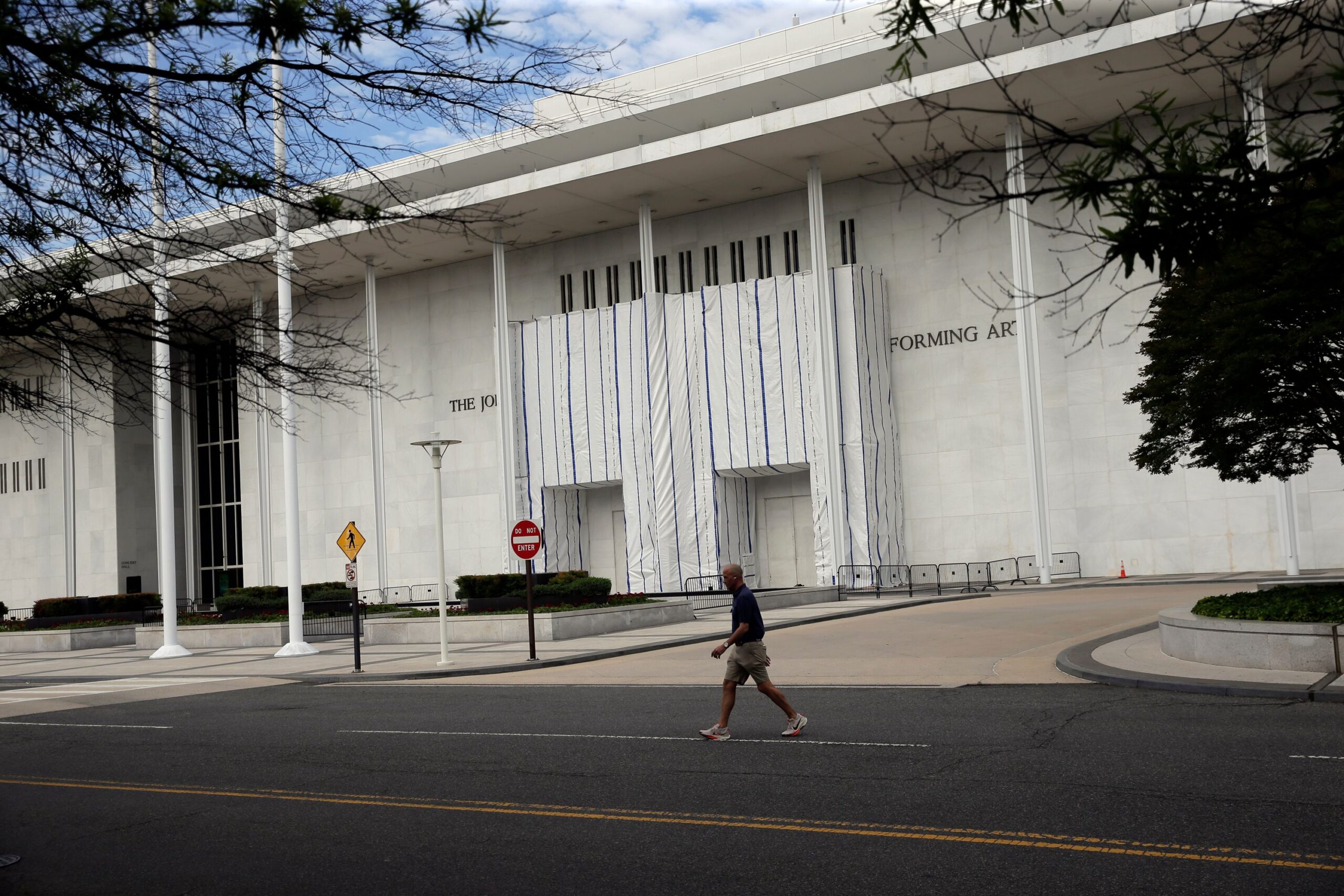 <i>Rahmat Gul/AP via CNN Newsource</i><br/>The wall of the John F. Kennedy Center for the Performing Arts is covered in tarp after President Donald Trump's name was removed