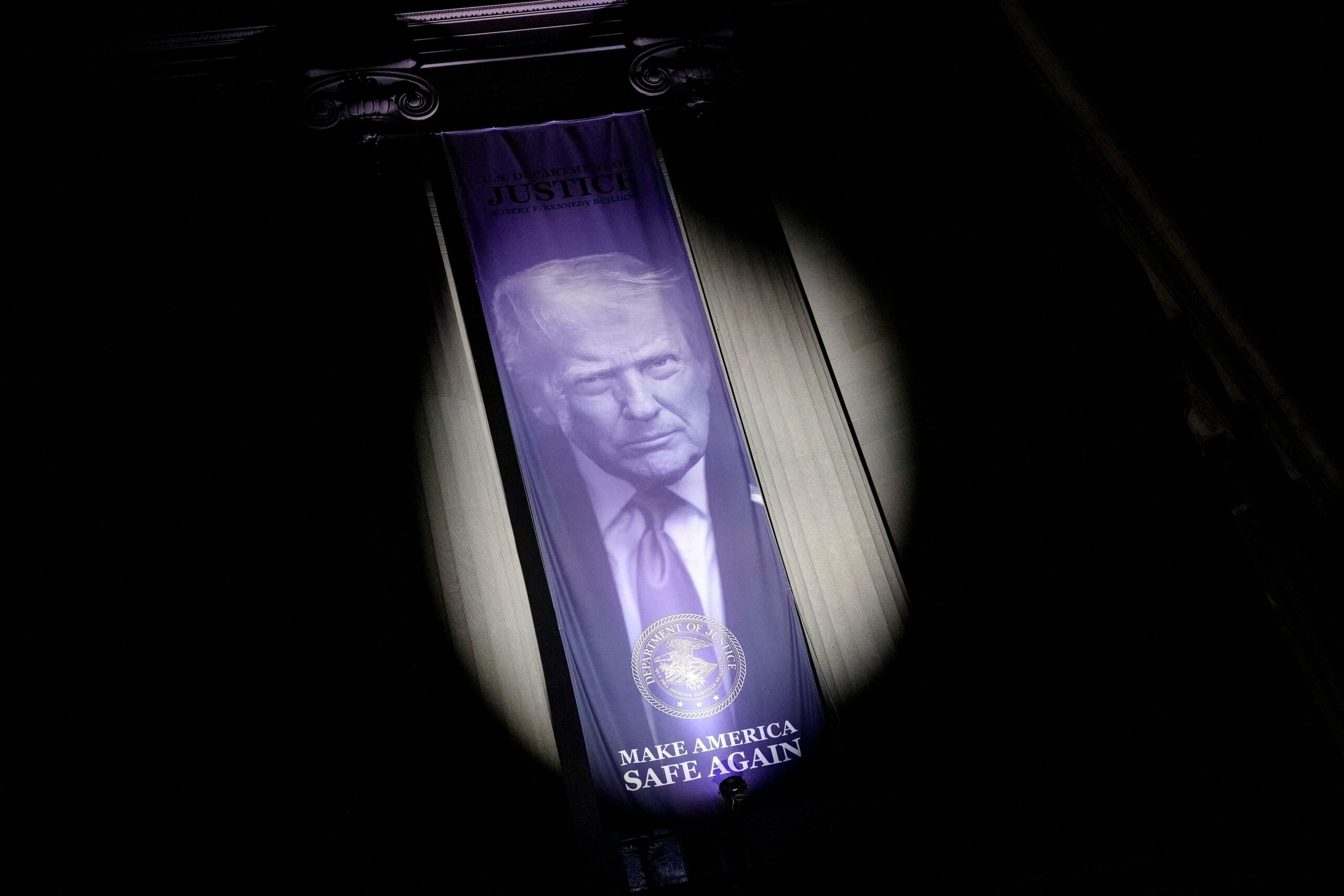 <i>Nathan Howard/Reuters via CNN Newsource</i><br/>A banner featuring a picture of President Donald Trump is displayed at the United States Department of Justice building