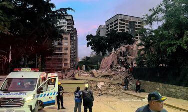Rescuers search for victims in a collapsed building in Caracas following an earthquake on June 24.