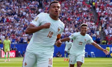 France's Ousmane Dembele checks on teammate Kylian Mbappe.