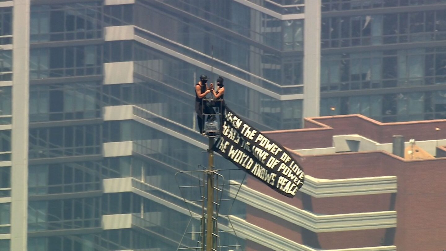 <i>WABC via CNN Newsource</i><br/>Two people scale to the top of the Empire State Building carrying a pro-peace banner on July 1.