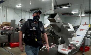 A federal agent takes part in an immigration raid at a Glenn Valley Foods meat production plant in Omaha